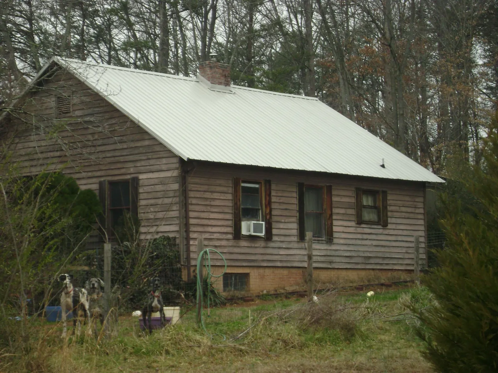 White metal roof on an old wood sided farmhouse, from a Metal Roof Installation job in Providence